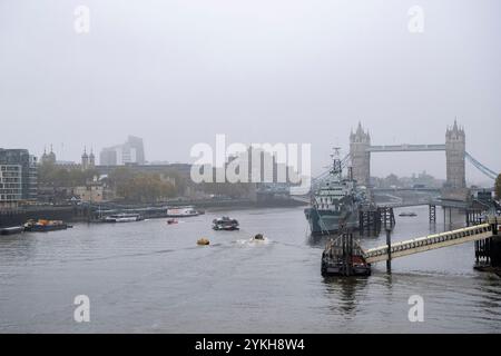 View of Tower Bridge with HMS Belfast moored on the River Thames on a misty day on 6th November 2024 in London, United Kingdom. Tower Bridge is a Grade I listed combined bascule and suspension bridge in London, built between 1886 and 1894, designed by Horace Jones and engineered by John Wolfe Barry with the help of Henry Marc Brunel. Stock Photo