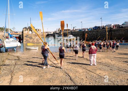 Pilot Gig crews carrying their oars waiting to board their Pilot Gigs for Women's Newquay County Championships Cornish Pilot Gig Rowing event at Newqu Stock Photo