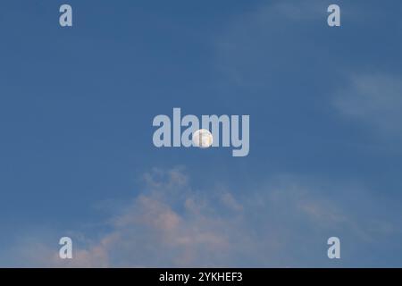 Full moon in the blue sky, with clouds, on a bright day. Stock Photo