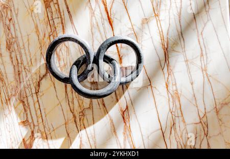 three round links attached and displayed on a marble background Stock Photo