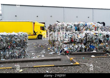 Used plastic milk bottles and cartons that have been bundled into stacked bales and ready for recycling at an industrial plastic waste recycling plant Stock Photo