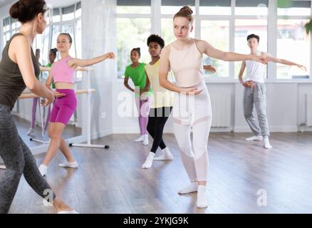 Teen girl practicing ballet movements at group class Stock Photo