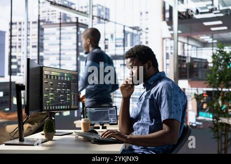 Computer scientist developing and maintaining machine learning APIs solving complex problems. African american man training predictive models capable of handling tasks such as language processing Stock Photo