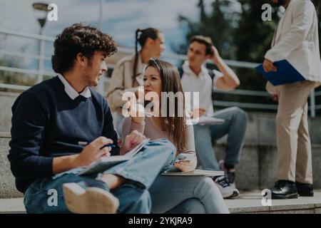 High school students collaborating outdoors with teacher assistance Stock Photo