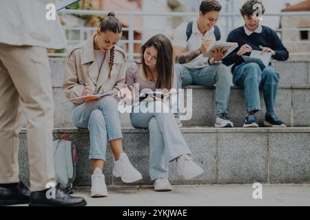 Students collaborating outdoors with a professor for academic success Stock Photo