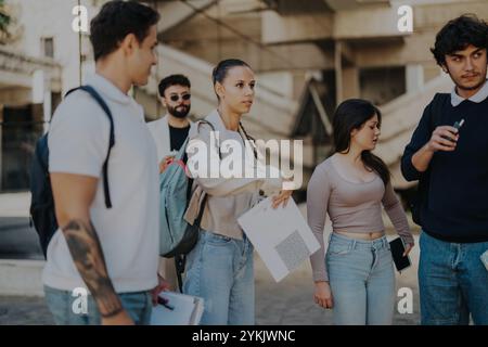 High school students collaborating outdoors with professor's guidance Stock Photo