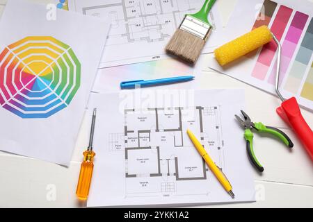 Designer's workplace with color palettes, floor plans and different supplies on white wooden table, flat lay Stock Photo
