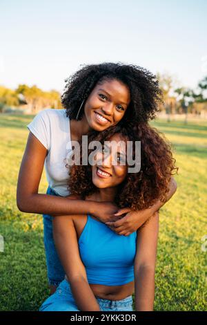 Two young beautiful black sisters outdoor posing looking over