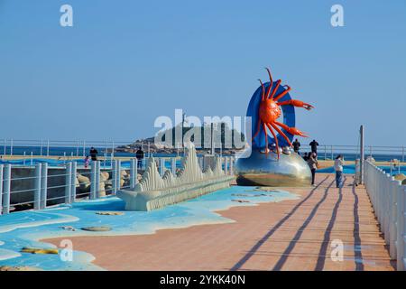 Sokcho, South Korea - November 3, 2024: A vivid crab sculpture sits prominently on the breakwater at Sokcho Beach, with Jodo Island and the East Sea p Stock Photo