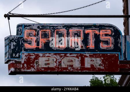 Old weathered neon sign reading Sports Bar with peeling paint on an old post Stock Photo