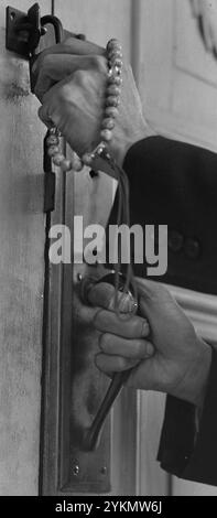 Buddhist prayer beads and hands detail, Florin, California. Hands of Reverend Naito (Buddhist priest) are here as he locks the door of his . . . Stock Photo