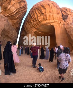 Mixed tourgroup viewing ancient Nabatean settlement of Jabar Ithlib, Hegra Archaeological Site (al-Hijr / Madā ͐ in Ṣāliḥ), in the desert near Al Stock Photo