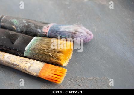 A creative setup featuring art brushes and a textured acrylic-painted surface. Stock Photo