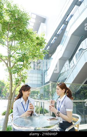 Two office workers drinking iced coffee outdoors Stock Photo