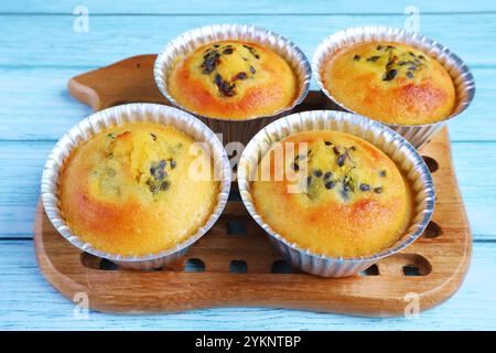 Freshly Baked Homemade Passion Fruit Muffins in Molds on Wooden Breadboard Stock Photo