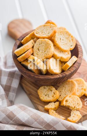 Sliced roasted bruschetta bread in bowl on a white table. Stock Photo