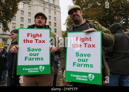 London, UK, 19th November 2024.Two farmers hold up protest signs. Farmers and their supporters hold a demonstration in Central London against the UK government’s recent changes to tax laws.  During Labours first budget in 14 years, Chancellor Rachel Reeves announced that farmers would lose exemptions when paying inheritance tax.   Farmers believe the upcoming change now means that owners of small and medium sized farms will face a higher tax liability in the future, causing hardship and an unwillingness to invest in infrastructure.  Credit: James Willoughby/Alamy Live News Stock Photo