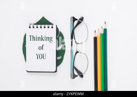 Open notepad on white background, flat lay, with message Thinking of You. Healthcare and mental care concept Stock Photo