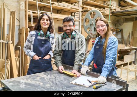 A group of young professionals and apprentices working together in a bustling lumberyard, showcasing teamwork and collaboration. They are wearing safe Stock Photo
