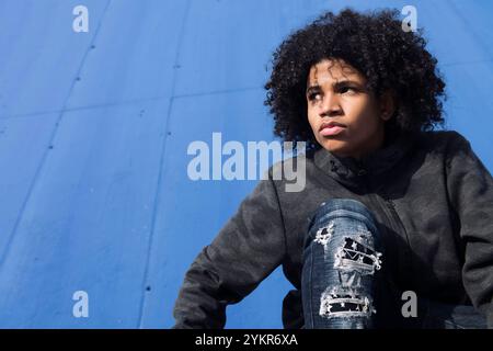 thoughtful curly haired teenager in informal wear Stock Photo