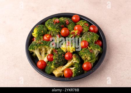 Broccoli cabbage marinated in spicy-sweet sauce and spices with cherry tomatoes. Preparing for baking. Healthy home cooking. Selective focus, close-up Stock Photo