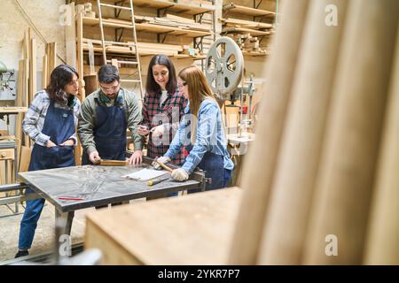 A group of diverse individuals work together in a lumberyard, showcasing teamwork and training. The setting highlights collaboration between younger a Stock Photo