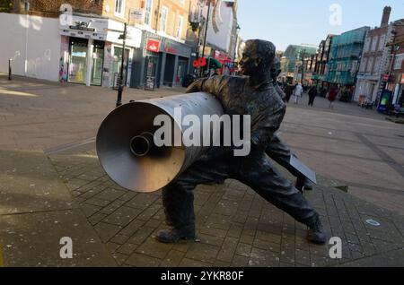 Statue of two men with a roll of lino linoleum commemorating the factor that stood by Staines High Street, Surrey, England Stock Photo