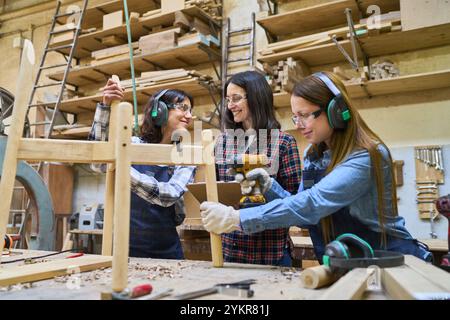 A diverse team of workers collaborates in a lumberyard, focusing on craftsmanship and skill development. The scene captures training, teamwork, and ap Stock Photo