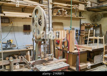 A detailed view of a traditional woodworking workshop, showcasing various tools, machinery, and wooden materials. The image highlights the craftsmansh Stock Photo
