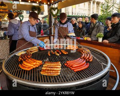 Bratwurst sausages being grilled at the German Sausage Company food stall at the Christmas market in Trafalgar Square, London, UK Stock Photo
