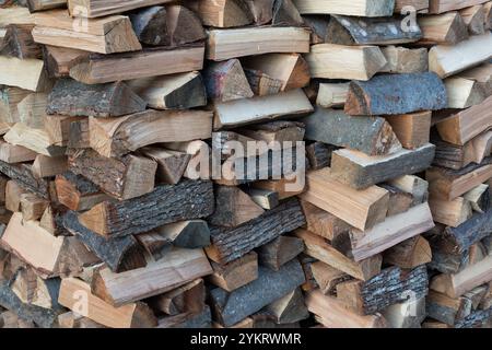 Pile of split wood stacked crosswise, pile of firewood Stock Photo