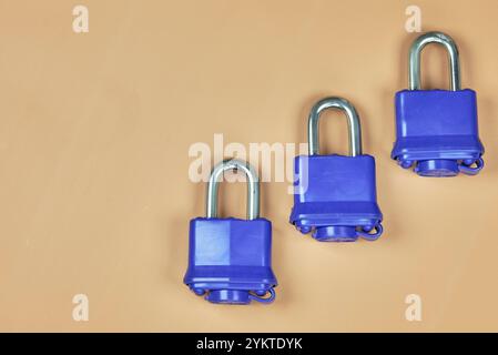 Padlock with blue plastic insulation and key, on a beige background ...