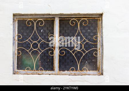 Antique Iron Grille on Rustic Window with Decorative Design Stock Photo