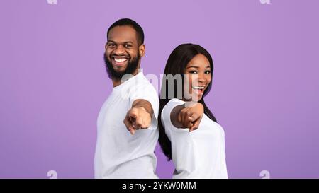 Smiling black couple pointing at camera, choosing you Stock Photo
