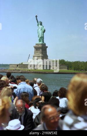 New York, USA, approx. 1992. Tourists on a ferryboat heading towards the Statue of Liberty Monument. Stock Photo