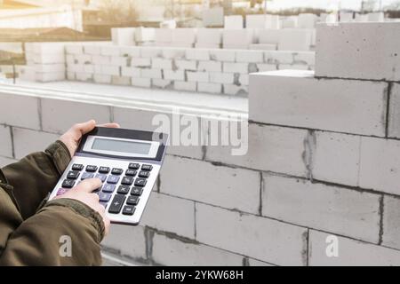 Construction costing concept. Calculating building materials. Calculator on background Aerated Concrete. Copy space Stock Photo