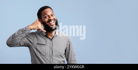 Afro man doing phone gesture at studio Stock Photo