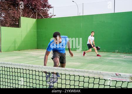 Two young friends playing paddle tennis on a court. Sports concept. Copy space Stock Photo