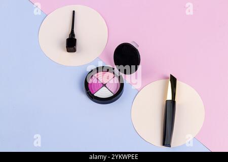 Top view make up accessories on pink and blue background. Eyeshadow palette and sticks Stock Photo