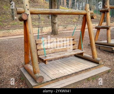 Wooden park swing made of logs Stock Photo