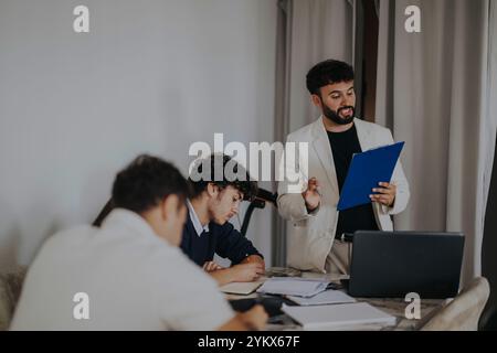 High school students collaborating on projects with a professor in a cozy setting Stock Photo