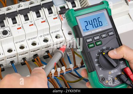 Electrician Testing Voltage in Circuit Breaker System with Multimeter Stock Photo