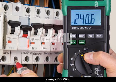 Electrician Testing Circuit Breaker with Multimeter Stock Photo