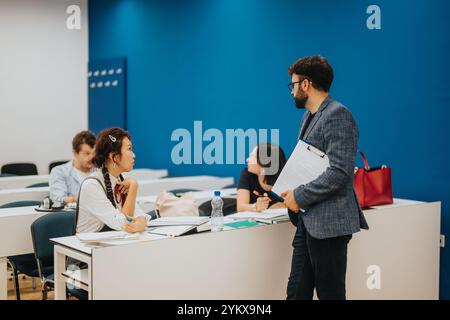 Professor assisting students during an interactive classroom session Stock Photo