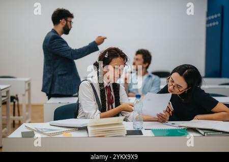 Professor assisting students during interactive classroom session Stock Photo