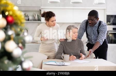 Couple discussing testament with elderly woman Stock Photo