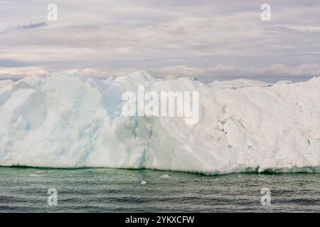 A striking close-up of an iceberg near Ilulissat, Greenland, showcasing the intricate details of its frozen surface. The iceberg’s jagged edges and cr Stock Photo