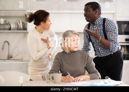 Couple discussing testament with elderly woman Stock Photo