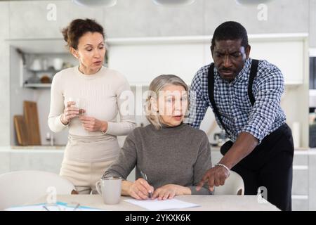 Couple discussing testament with elderly woman Stock Photo