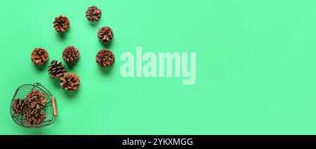Basket and scattered pine cones on green background with space for text Stock Photo